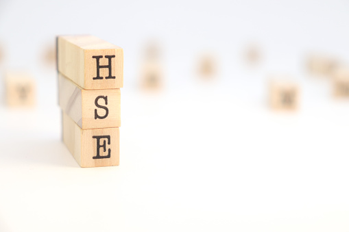 HSE (Health Safety Environment) acronym isolated in wooden cubes on white background.