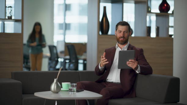 istock Joyful man discussing tablet computer at corporate hall closeup. Successful work 2115394919