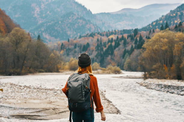 istock woman wearing a hat backpack landscape mountains model gesturing with hands 2115402767