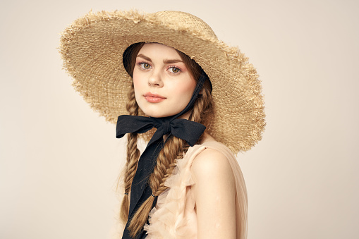 romantic girl in beige dress and in straw hat with black ribbon emotions portrait of model cropped view. High quality photo
