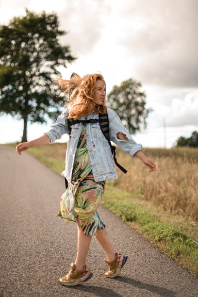 istock Walking the path. Girl with a longboard by her side. 2115478208