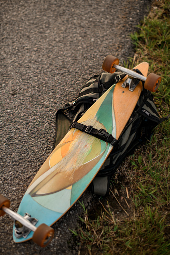 In serene stillness, a longboard calmly lies on the quiet and open road, awaiting movement.