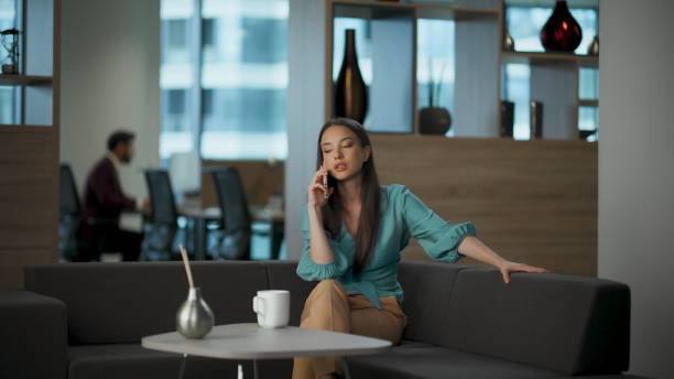 istock Serious entrepreneur having call at workroom. Businesswoman drinking coffee 2115483578