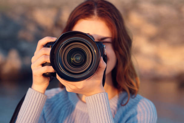 istock woman with professional camera outdoors in mountains front view 2115486714