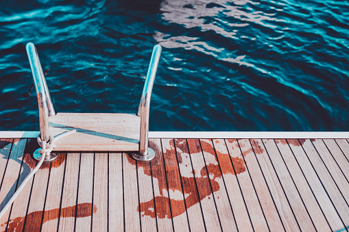 Footprints on dock of sailboat, in summer
