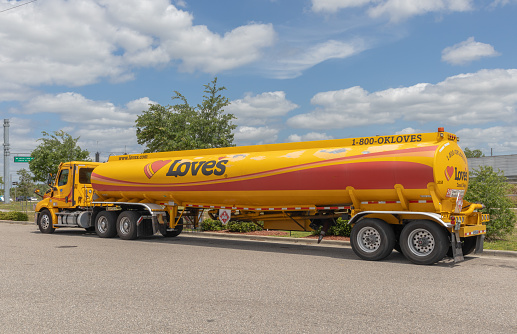 Davenport, FL, USA, 3-26-24. yellow and red gas tanker truck depositing fuel at Loves Truck Stop station with copy space