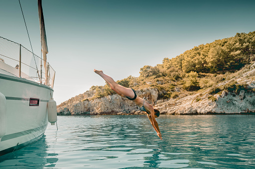 Photo of a couple jumping into the sea from the boat