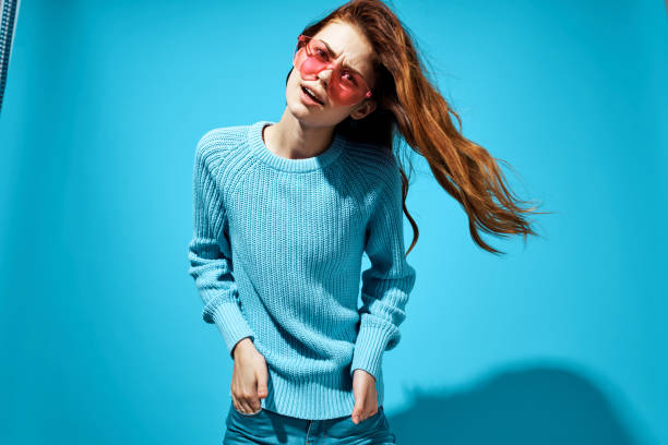 istock cheerful woman blue sweater glasses posing emotions studio blue background 2115546462