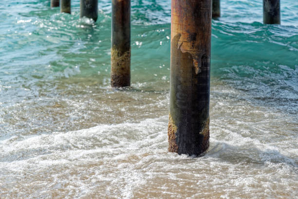 istock Wavy sea water at pier pillars 2115554894
