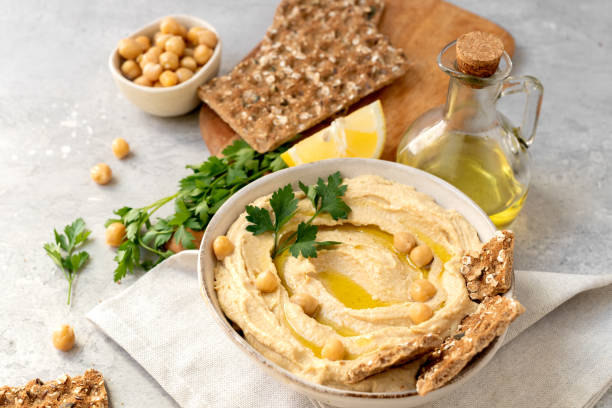 istock Fresh hummus with chickpea olive oil and lemon  with multigrain crackers 2115598210