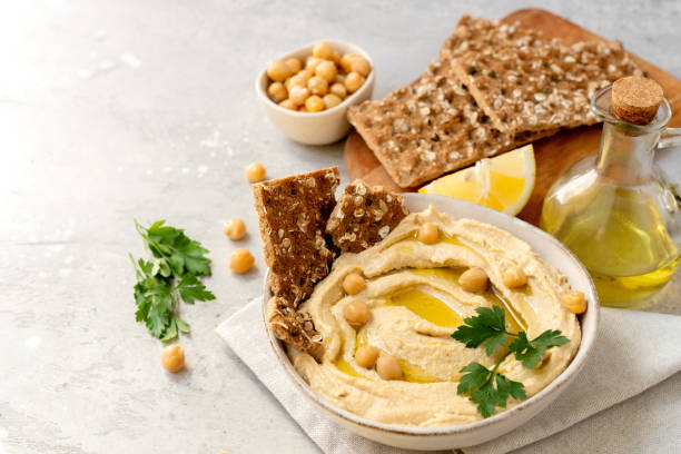 istock Fresh hummus with chickpea olive oil and lemon  with multigrain crackers 2115598213