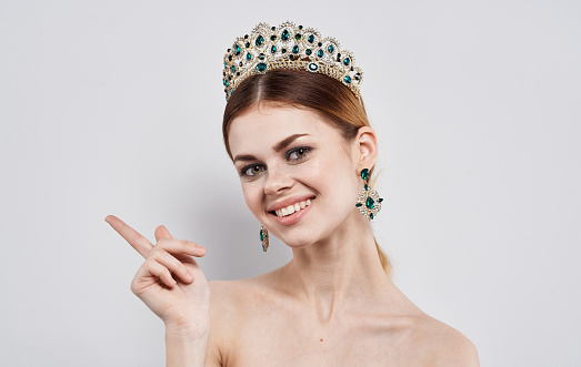 Emotional woman with a diadem on her head and beautiful earrings model. High quality photo
