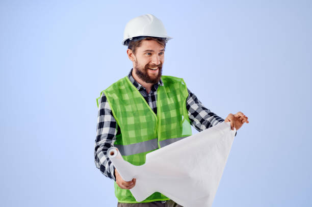 istock male builder in a white helmet blueprints Professional blue background 2115626994