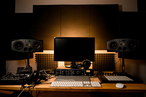 Escritorio de estudio de grabación con monitor y todo el equipo necesario para la grabación de música, Macbook, sintetizador photo