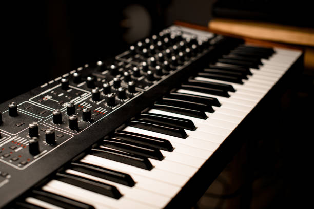 Close up of synthesizer, special professional equipment in modern recording studio on blurred dark background