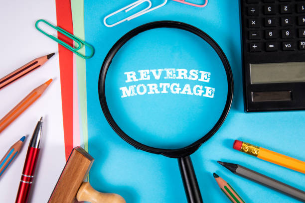istock Reverse Mortgage. Magnifying glass and stationery on the office table 2115647546