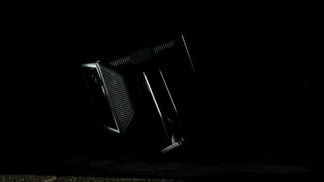 Blow of a hammer to a monitor, isolated on a black background, steady shot