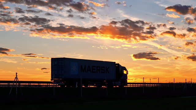 Silhouette Cargo Trucks Driving on Highway in Countryside During Sunset in Slovenia