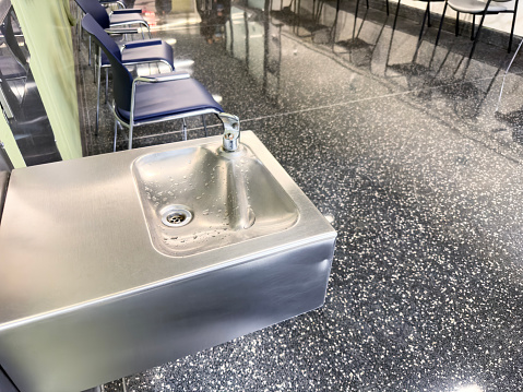 Water drinking fountains attached on a wall in a  hospital corridor