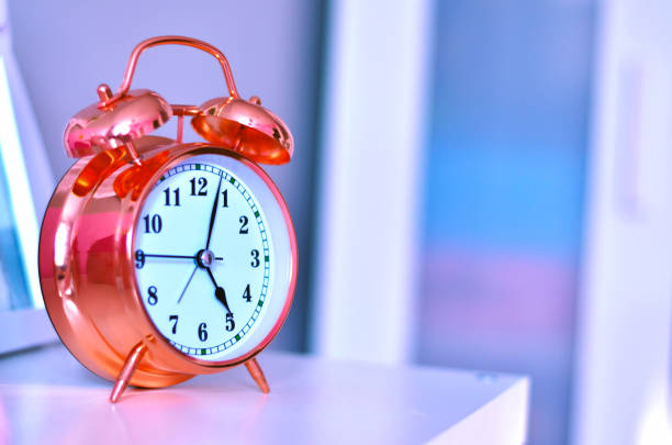 Pink alarm clock on the shelf. Close up.