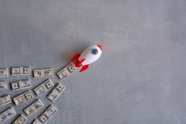 istock Rocket blasts off through a pile of money. 2115800638