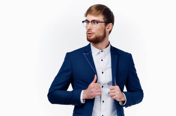 istock blond man in classic suit straightens jacket sleeve cropped view 2115801657