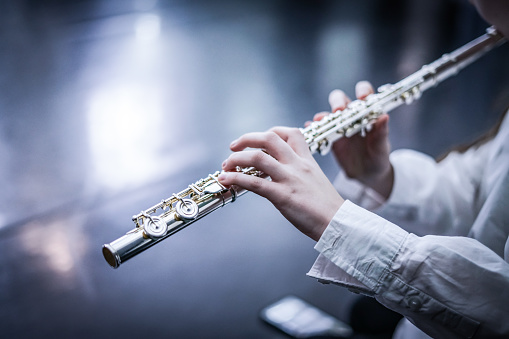Playing the transverse flute. Close up.