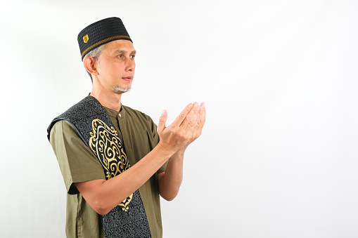 Portrait of Asian Moslem Man praying, side view