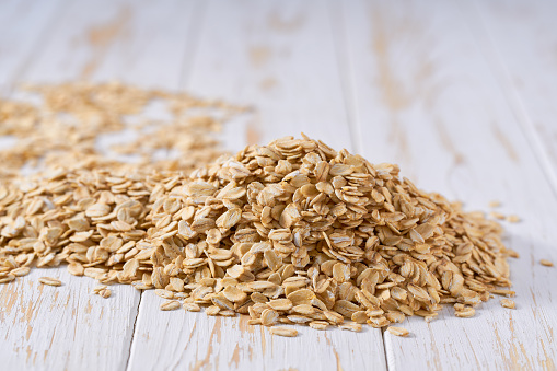 Organic oatmeal flakes on a light table, selective focus. Pile raw dry rolled oats on a light table, selective focus.