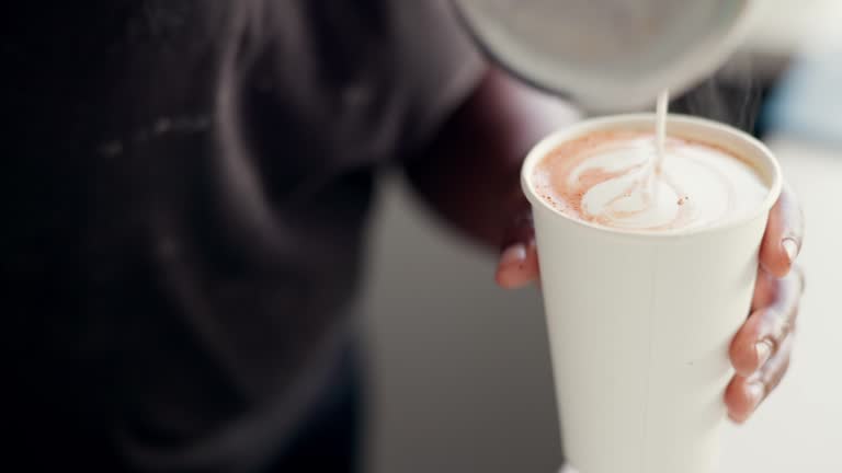 Latte, art and hands of barista pouring in coffee cup, cappuccino and creative espresso in cafe, restaurant or bistro. Milk, foam or small business server drawing pattern in caffeine drink with steam