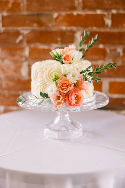 istock A simple wedding cake decorated with pretty flowers against a red brick wall 2115839168