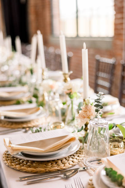 istock An elegant table at a wedding reception decorated with plates, candlesticks, florals, and napkins topped with the dinner menu. 2115842757