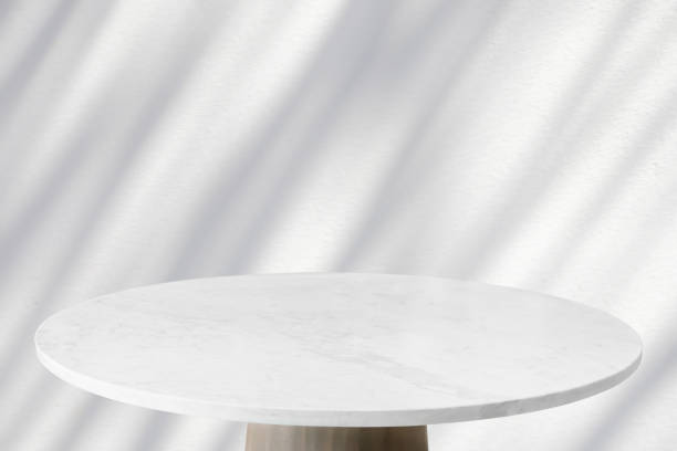 istock Round marble table top with tree leaves shadow drop on white wall background for mockup product display 2115845928