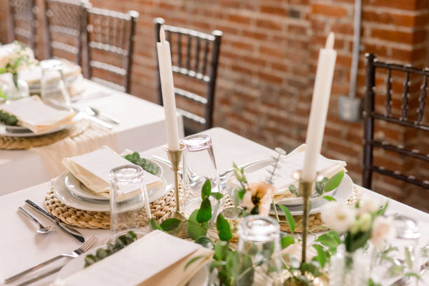 istock A beautiful white tablecloth table is decorated with tall candlesticks, greenery and small florals, and beautiful place settings. 2115848210