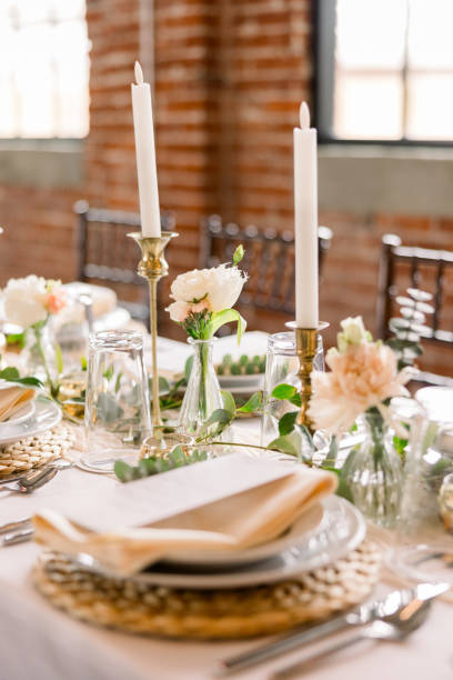 istock A gorgeous wedding reception table decorated with a place setting on a wicker placemat, a napkin, and the menu on top, and candlesticks on the table. 2115850456