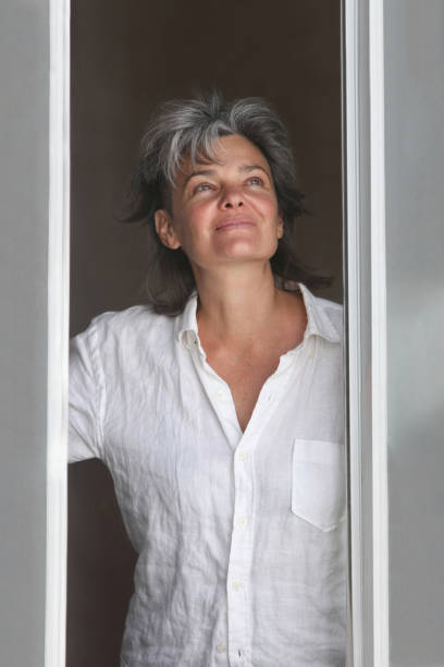 istock happy woman in the window 2115896712