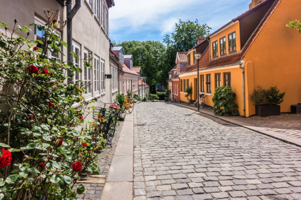 bajkowa dzielnica miejsca urodzenia hansa christiana andersena, która zainspirowała fantastyczne opowieści na turystycznej ulicy paaskestraede z brukowanymi drogami, wielokolorową architekturą i domami z rowerami pod ścianą w odense w danii - hans christian andersen odense town denmark zdjęcia i obrazy z banku zdjęć