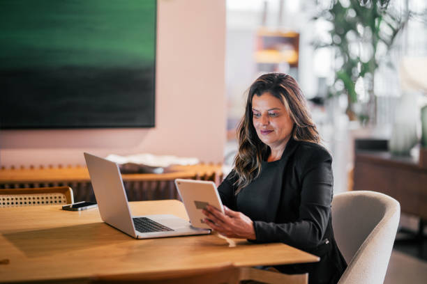 istock Beautiful woman, sitting and using a digital tablet 2115932067