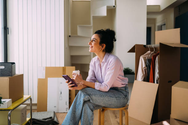 istock Young Woman Enjoying a Break While Moving Into New Home 2115959780