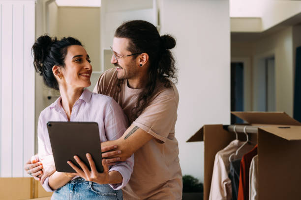 istock Affectionate Couple Planning Their New Home Together Holding Tablet 2115960297