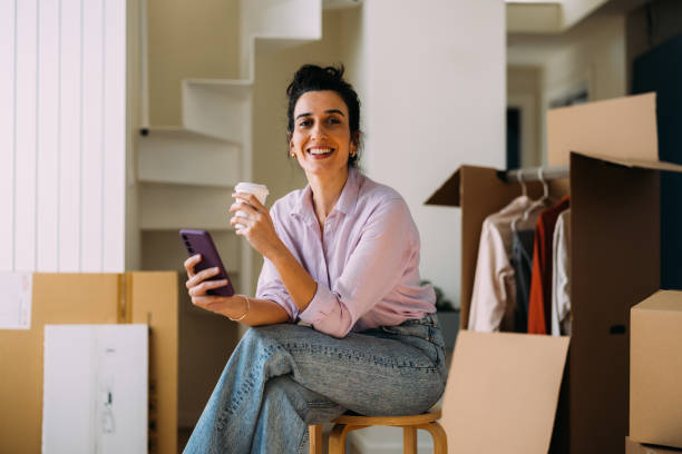 istock Smiling Woman with Coffee Enjoying a Break During Moving Day 2115960300