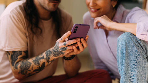 istock Friends Sharing a Fun Moment on a Smartphone Indoors 2115960325