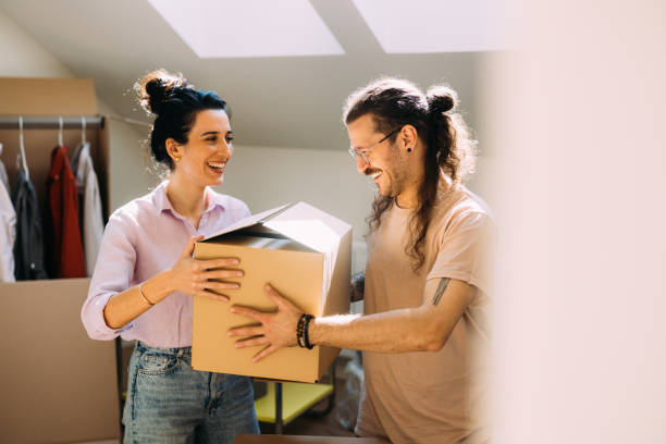istock Happy Couple Moving in Unpacking Boxes in Sunlit Home 2115960856