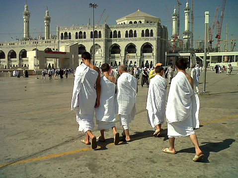 Mecca, Saudi Arabia- 10/15/2012:
Ihram clothing is worn by Muslim men and women during the Islamic pilgrimages of Hajj and Umrah to avoid drawing attention. The clothing consists of two white, simple pieces of cloth, the Izar and the Rida, that are wrapped around the body. The Izar covers the lower body, while the Rida covers the upper body like a shawl. The Izar is wrapped around the waist, covering the area between the navel and feet, while the Rida covers the left shoulder at all times. The right shoulder should be exposed while performing the tawaf.