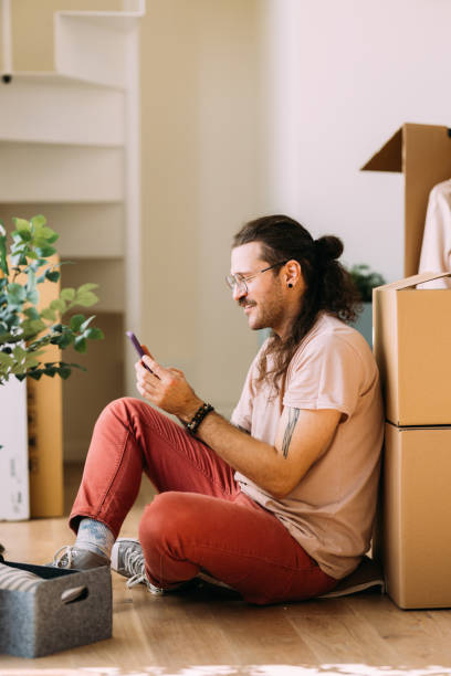 istock Young Man Enjoying a Break on Moving Day in New Home 2115960901