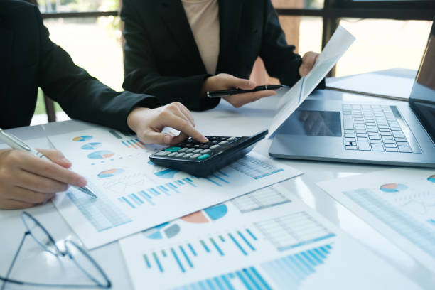 istock Two people are working on a project, one of them is using a calculator 2115962555