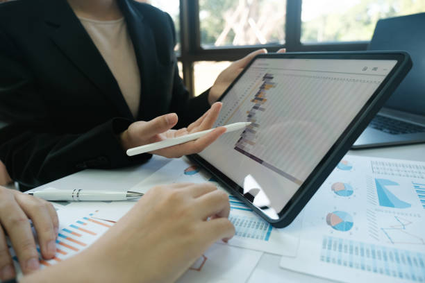 istock Two people are looking at a tablet with a graph on it 2115962569