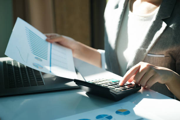 istock A woman is sitting at a desk with a calculator 2115962579