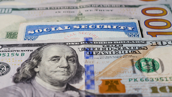 Photo of social security card with one hundred dollar bills