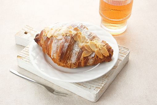 Almond Croissant with sprinkling icing sugar on white plate